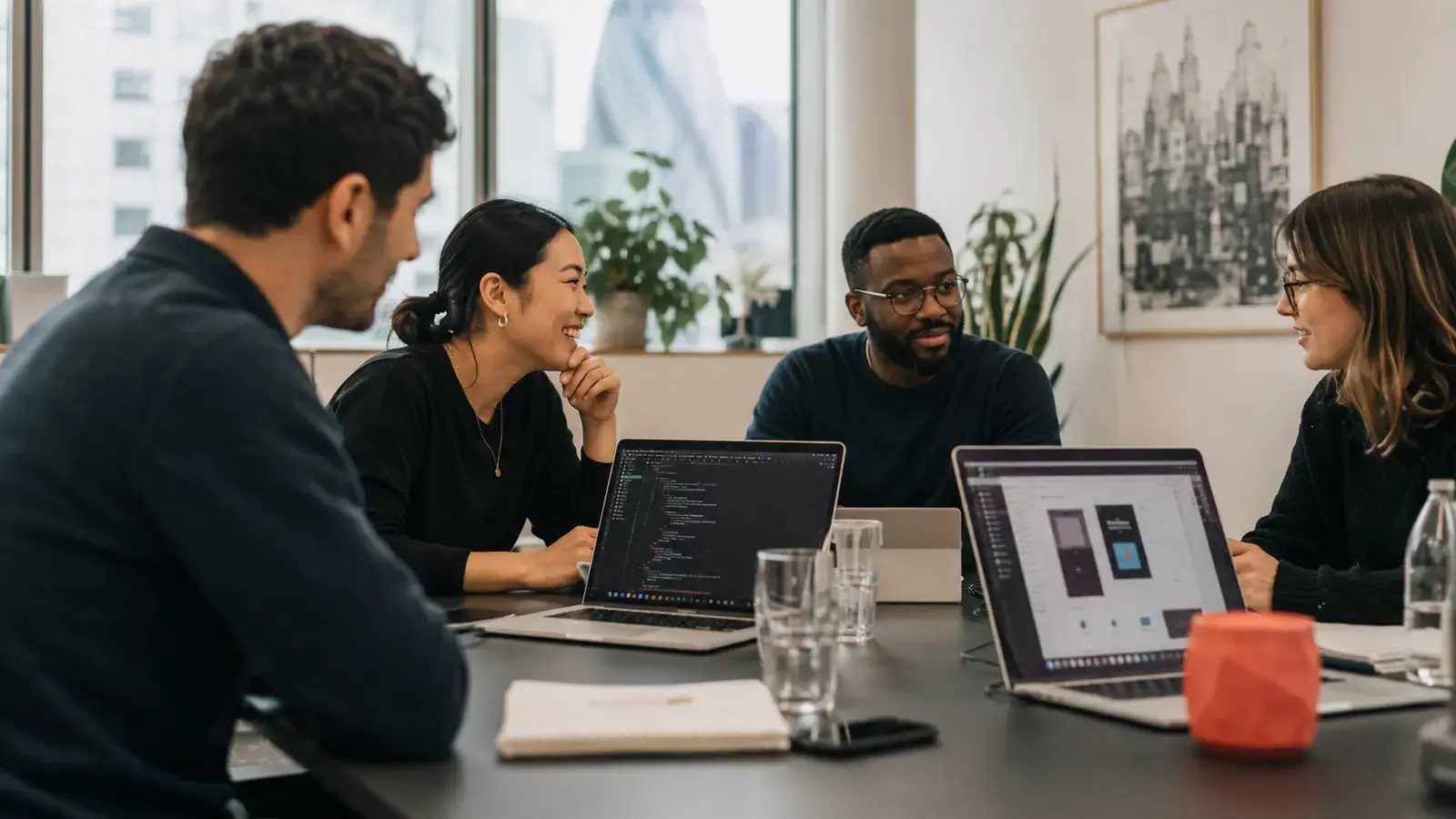 The Zevnotix team collaborating around laptops in a modern London office